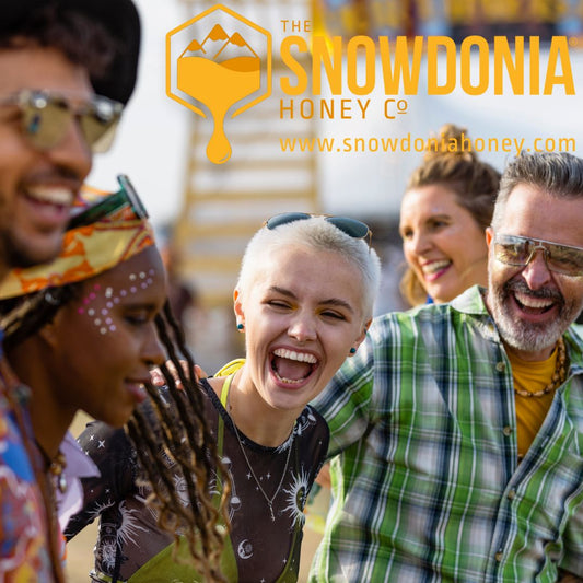 four people enjoying themselves and laughing at a honey festival